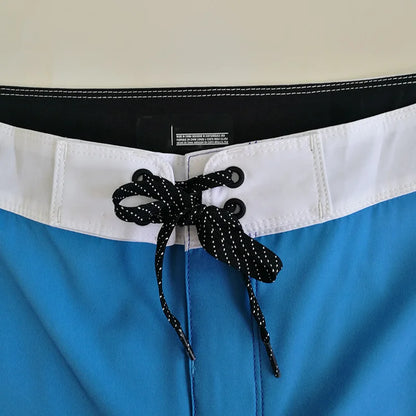 Close-up of blue shorts with a black waistband and decorative bow.