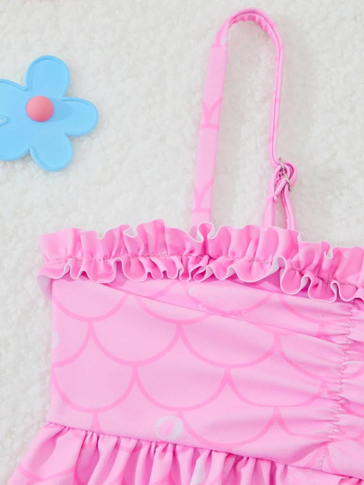 Pink swimsuit with ruffled details on a light gray background