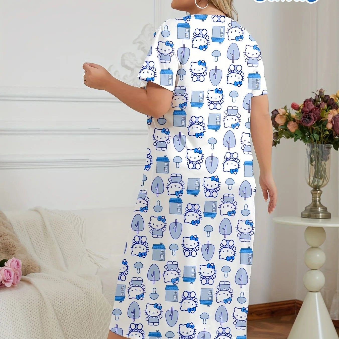 Woman wearing a Hello Kitty patterned nightgown in a room with a white couch and decorative items.