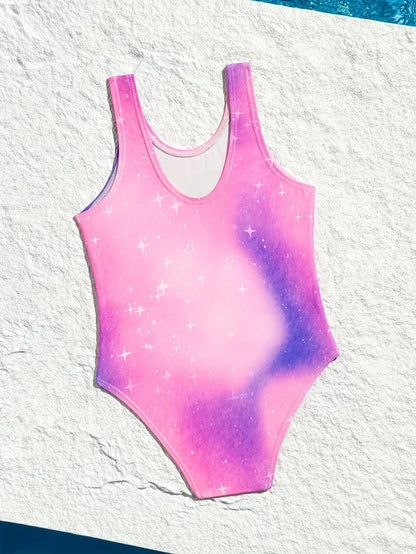 Pink and purple tie-dye swimsuit with star patterns on a textured white background