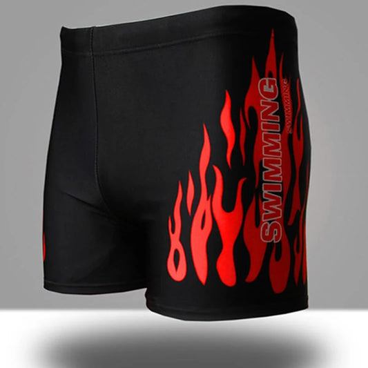 Black swim shorts with red flame design on a gray background