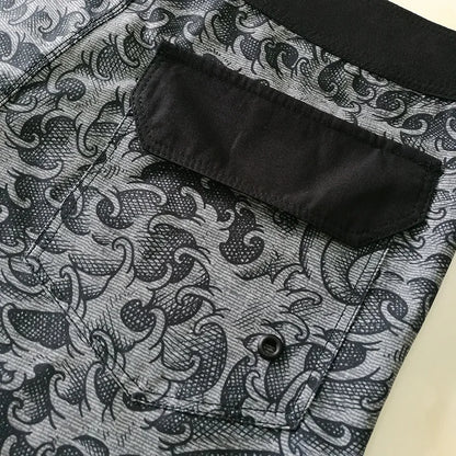 Close-up of a black patterned shirt with a pocket on a textured fabric background