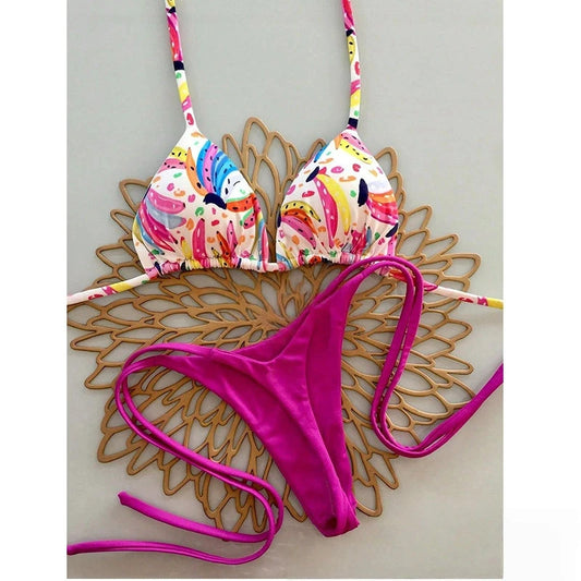 Colorful bikini top with floral design and pink bottom on a wooden surface