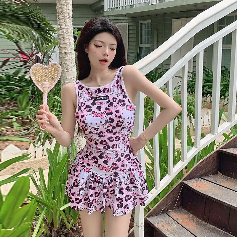 Woman in a pink dress with Hello Kitty design holding a heart-shaped mirror outdoors.