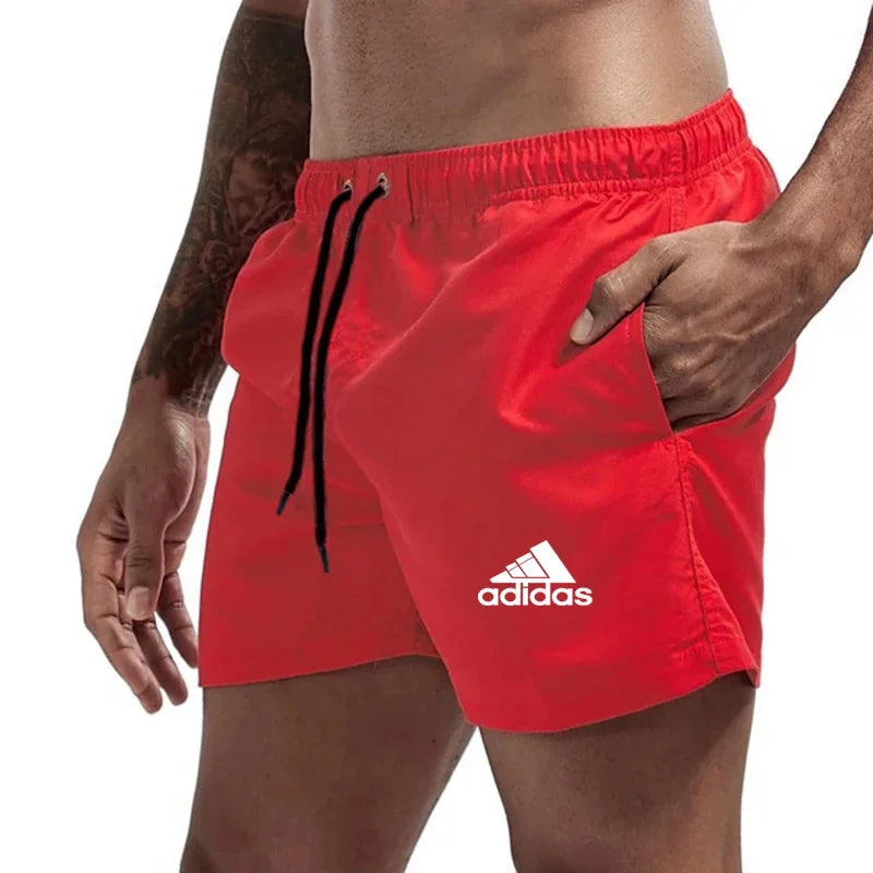 Red Adidas shorts worn by a person on a white background
