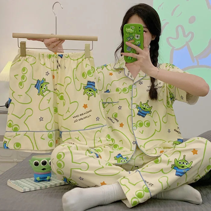 Person wearing a green and white pajama set with cartoon characters, sitting on a bed.