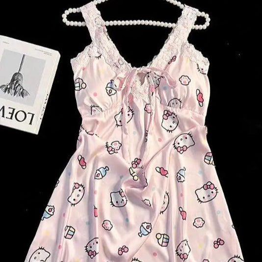 Pink babydoll dress with cartoon print on a hanger against a black background