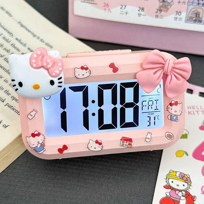 Hello Kitty-themed digital clock on a surface with a calendar in the background