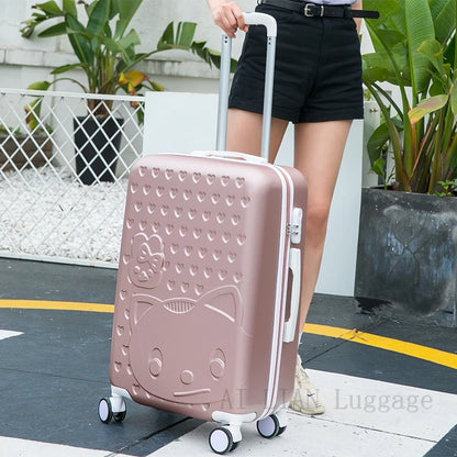 Person holding a pink suitcase with a cat design outdoors.