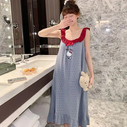 Woman in a blue dress with red top and Hello Kitty design, holding a teddy bear in a bathroom.