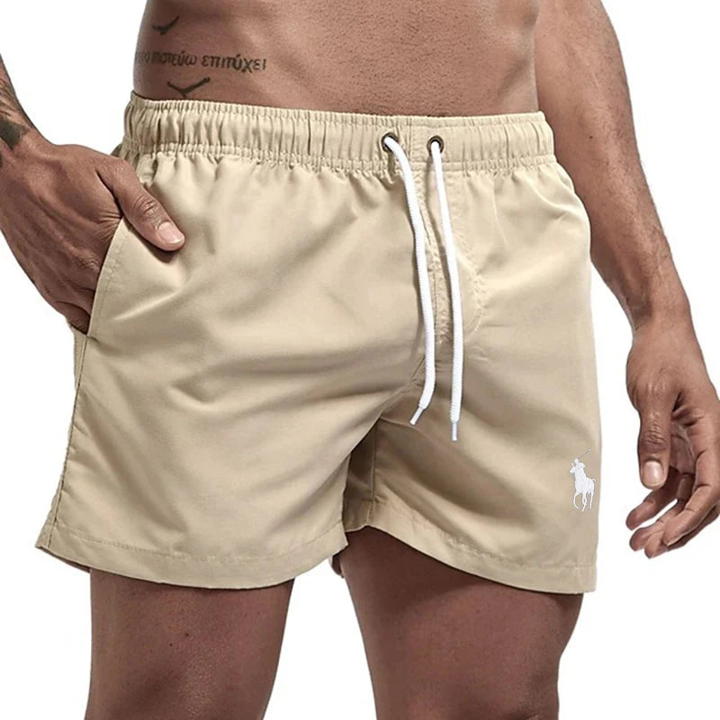 Beige shorts with a white drawstring and logo on a plain background
