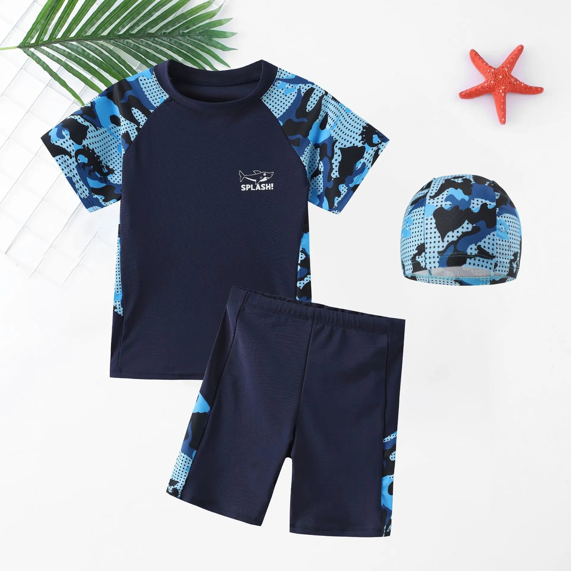 Navy blue swim set with blue and black patterned sleeves and shorts, accompanied by a matching swim cap on a white background.