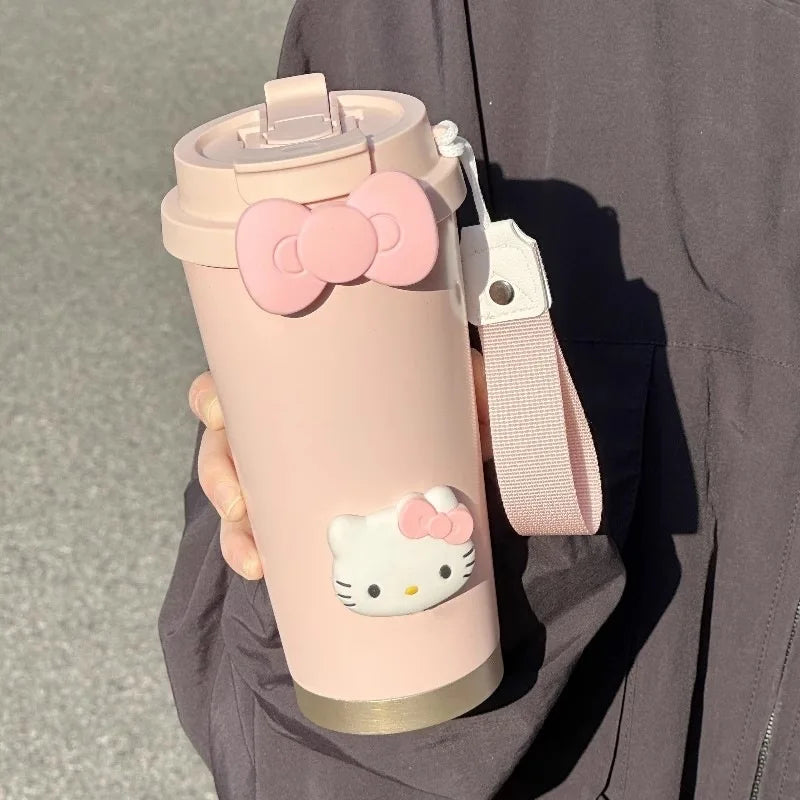 Pink water bottle with Hello Kitty design held by a person