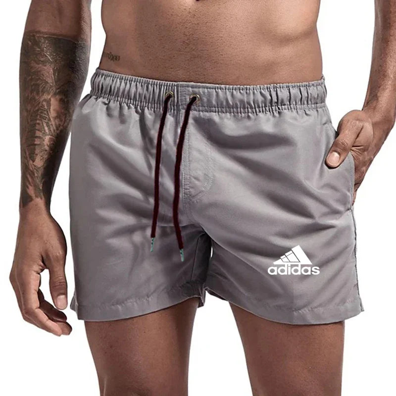 Gray Adidas shorts worn by a person on a white background