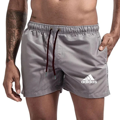 Gray Adidas shorts worn by a person on a white background