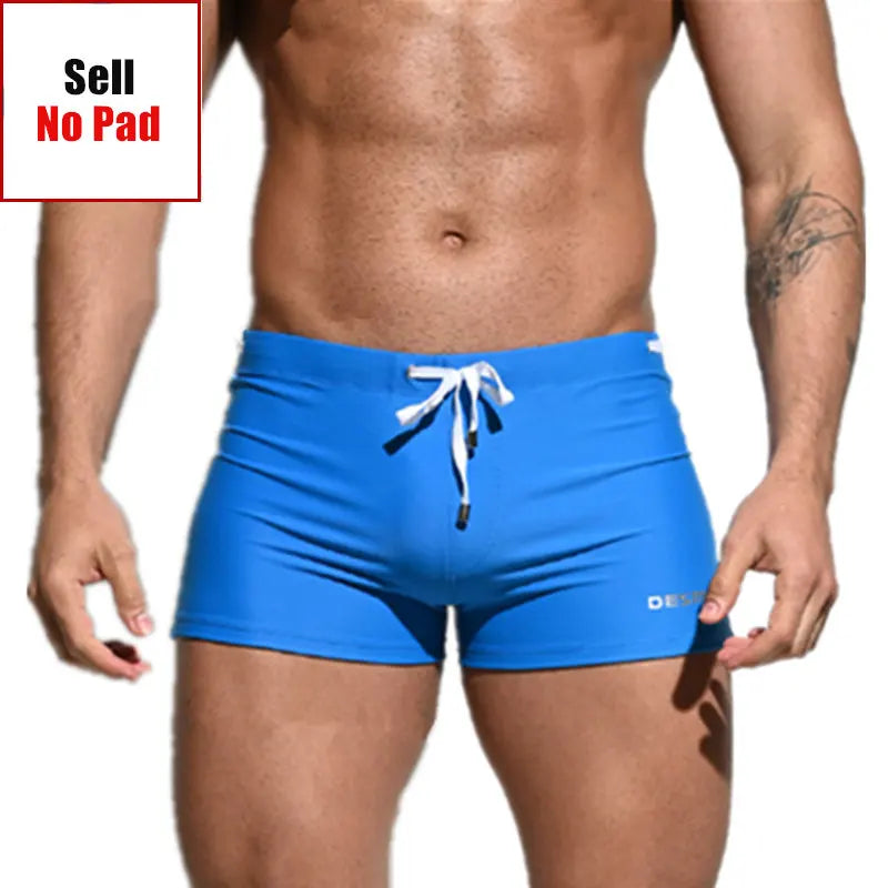 Blue swim shorts with a white drawstring on a plain background