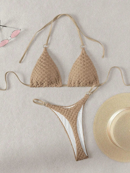 Beige crochet bikini set on a light background with a straw hat.