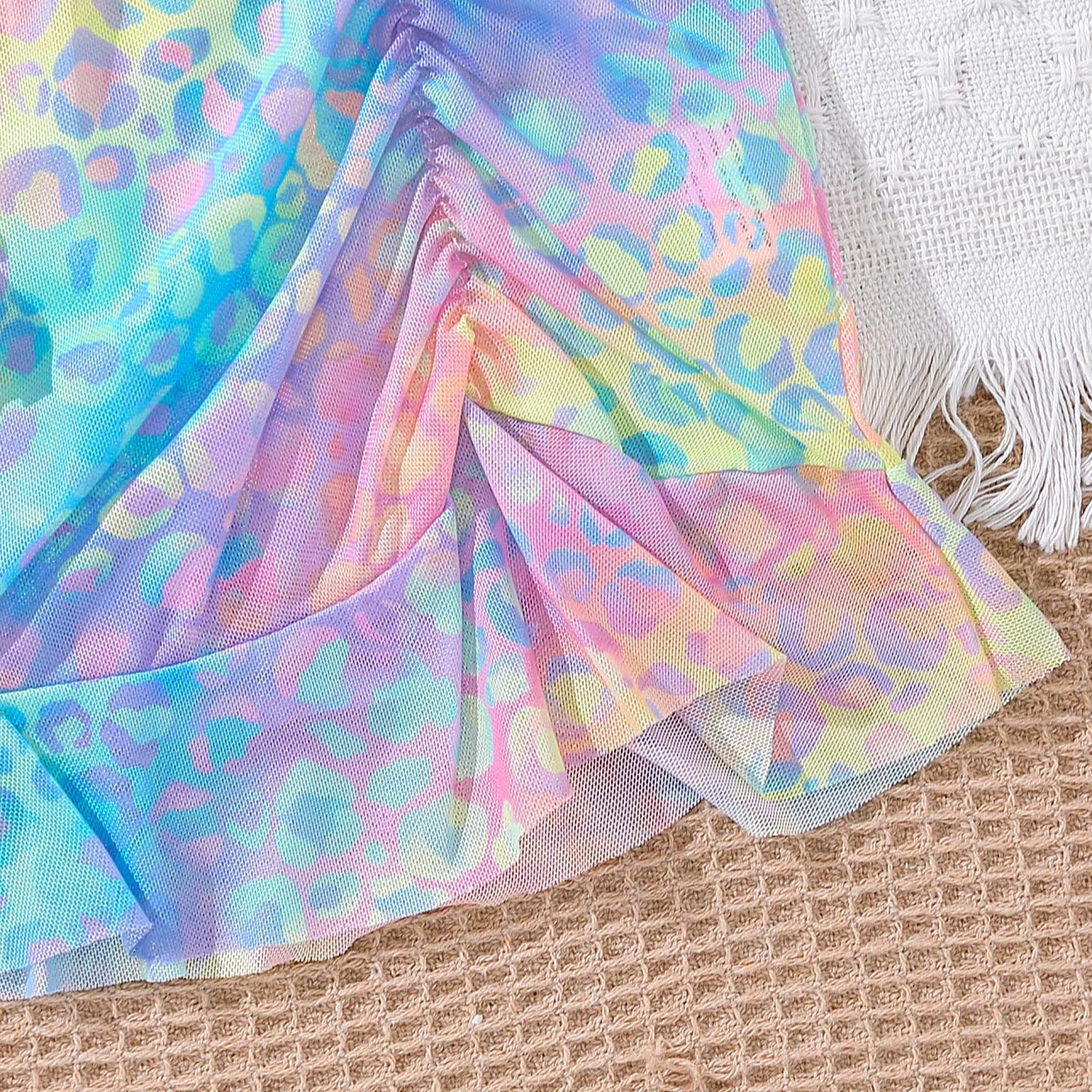 Colorful leopard print fabric on a textured surface