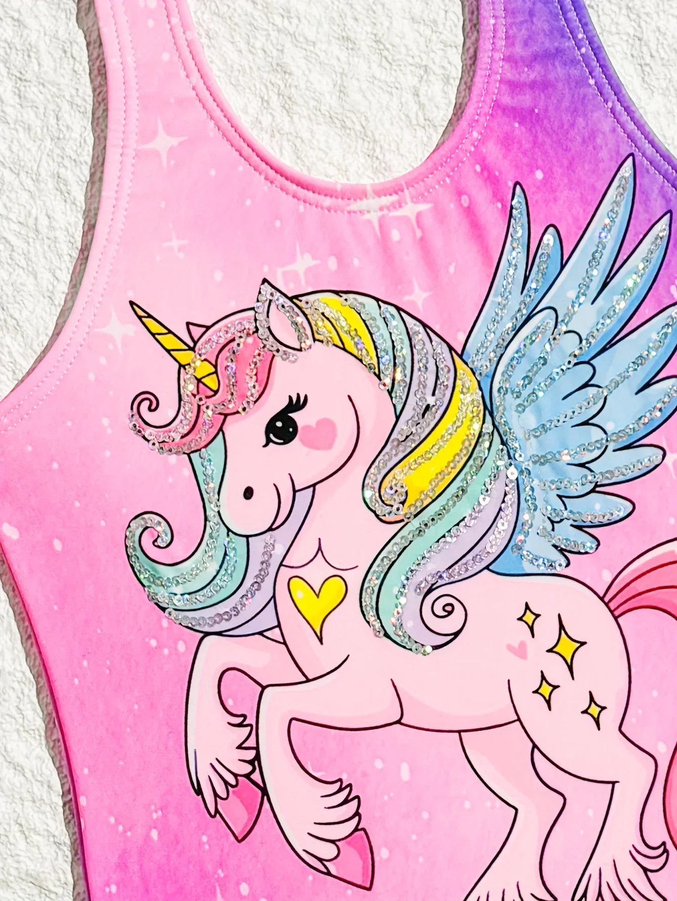 Pink tank top with a colorful unicorn design on a white background