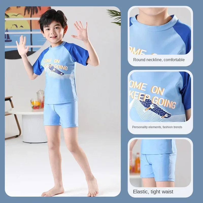Child wearing a blue and navy swimsuit with 'COME ON KEEP GOING' text, set against a minimal indoor background.