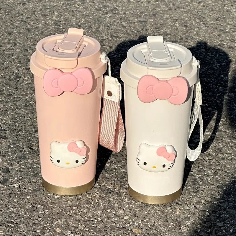 Two Hello Kitty-themed tumblers on a textured surface