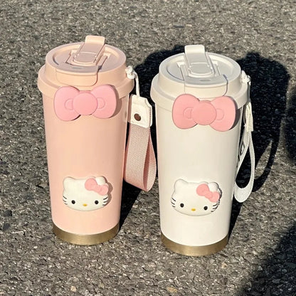 Two Hello Kitty-themed tumblers on a textured surface