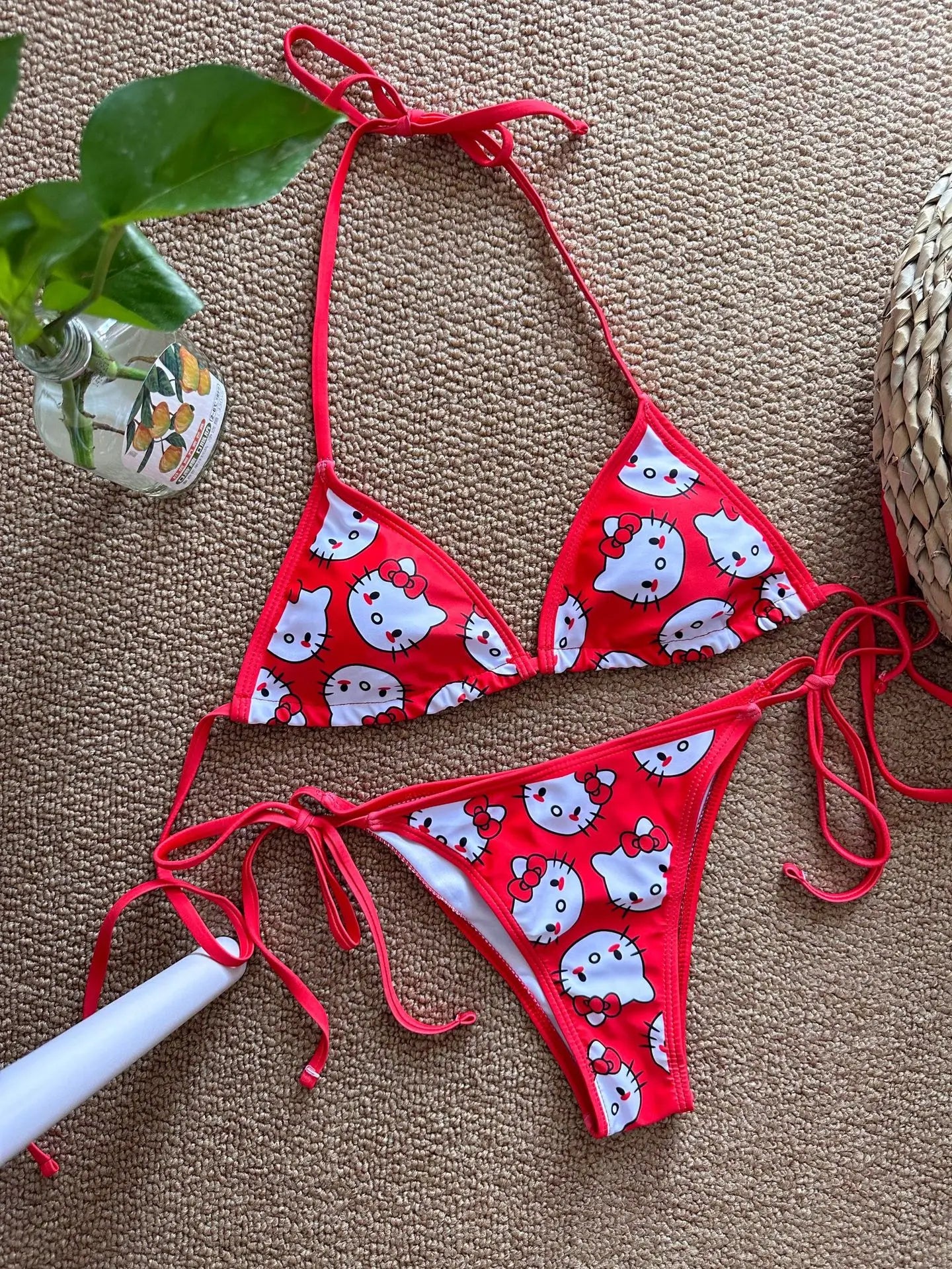 Red bikini with white cat pattern on a brown surface