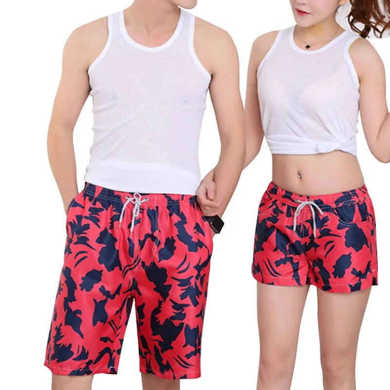 Two people wearing matching red and black patterned shorts with white tank tops.