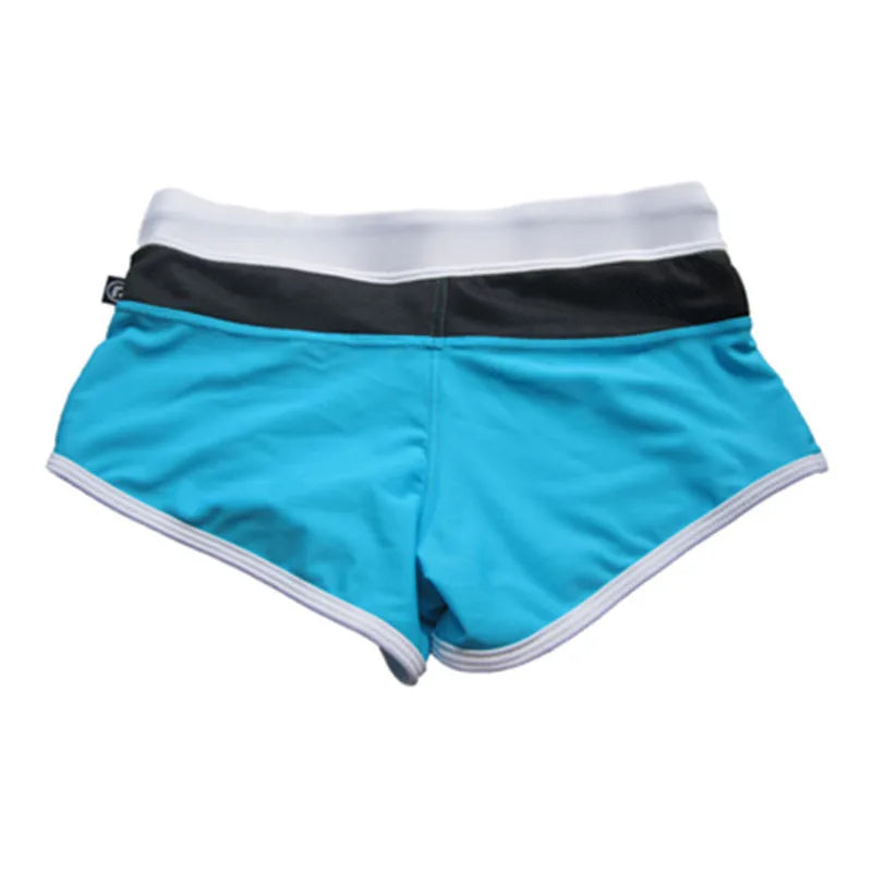 Turquoise shorts with black waistband and white trim on a white background