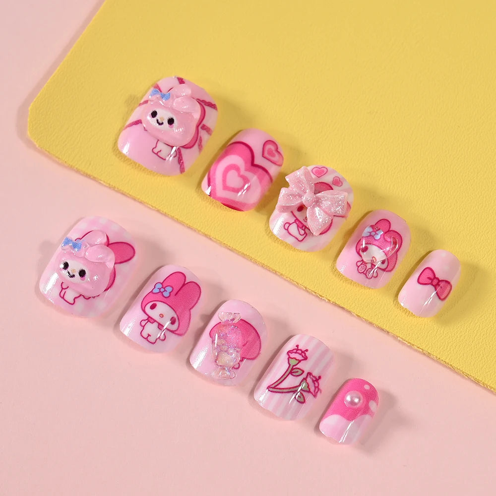 Set of cartoon-themed false nails on a pink and yellow background