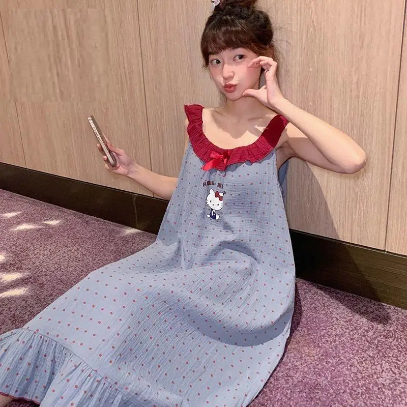 Woman wearing a blue dress with a red collar and Hello Kitty design, sitting on a pink carpet.