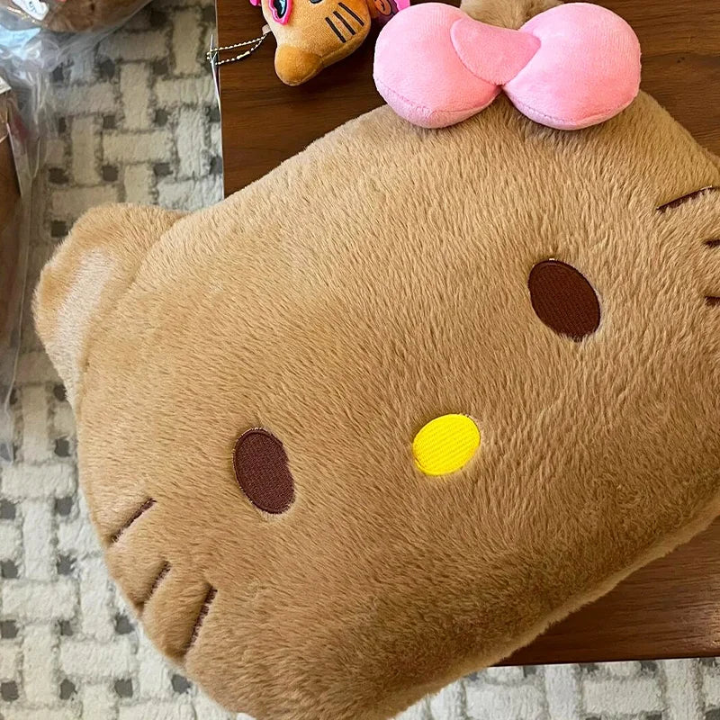 Plush toy resembling a cat with a pink bow on a wooden surface