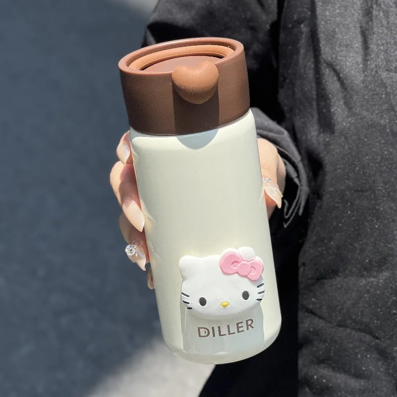 Person holding a Hello Kitty-themed tumbler with a brown lid against a dark background