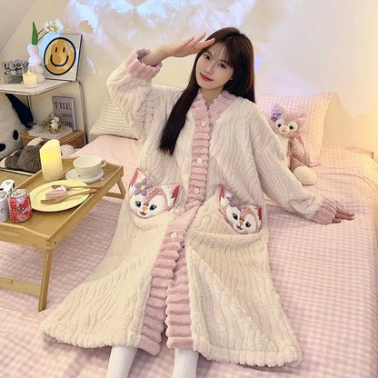 Woman wearing a long, light-colored cardigan with cartoon character pockets in a cozy room.
