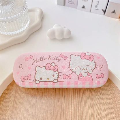 Pink 'Hello Kitty' glasses case on a wooden surface with decorative items in the background.