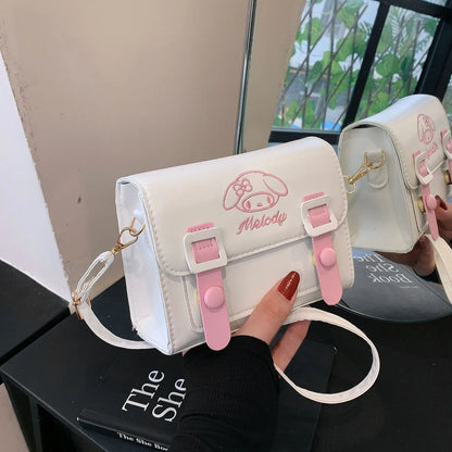 White and pink bag with 'Melody' branding held by a hand on a black surface.