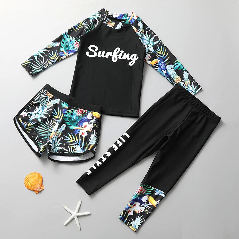 Surfing-themed swimwear set with floral sleeves and pants on a gray background