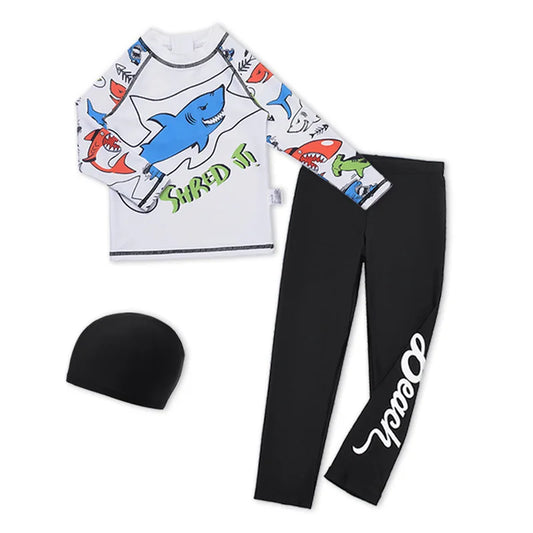 Children's shark-themed rash guard, black leggings with 'Ocean' print, and black beanie on a white background