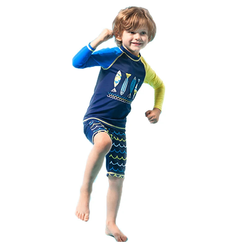 Child wearing a blue and yellow swim set with fish design on a white background