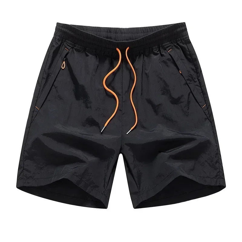 Black shorts with orange drawstring on a white background
