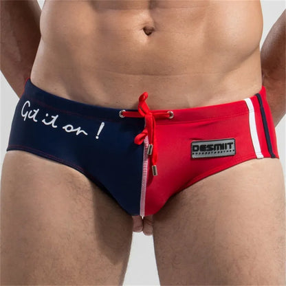 Two pairs of men's swim briefs, one navy with white text and one red with a brand logo, on a plain background.