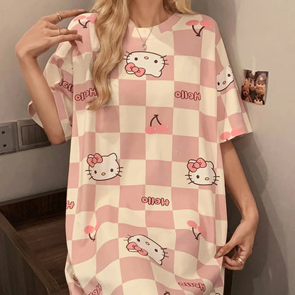 Person wearing a checkered dress with Hello Kitty patterns in a room.