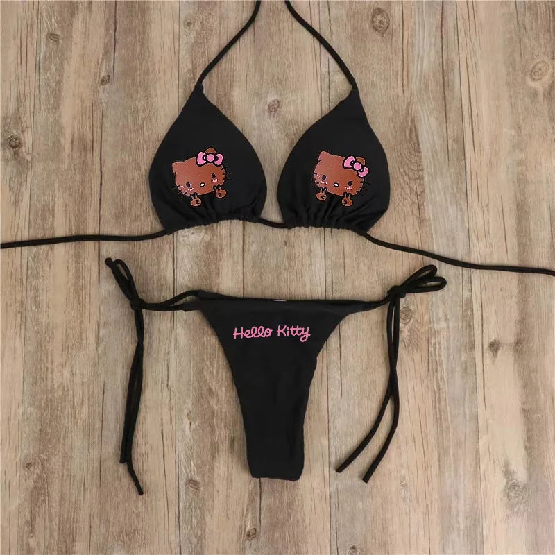 Black bikini set with Hello Kitty design on a wooden surface