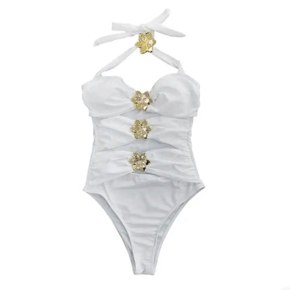 White swimsuit with gold floral embellishments on a white background