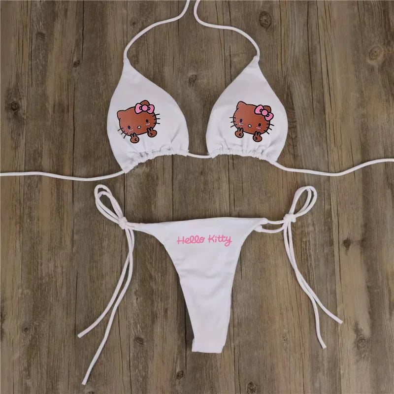 White bikini set with Hello Kitty design on a wooden surface