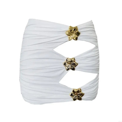 White pleated top with gold floral embellishments on a white background