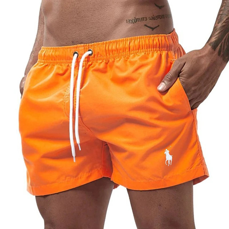 Orange swim shorts with a white drawstring and logo on a white background
