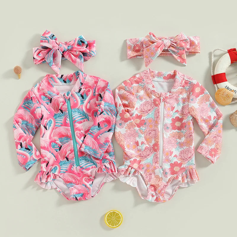 Two children's swimsuits with floral and flamingo patterns, accompanied by headbands and a lemon decoration on a light background.