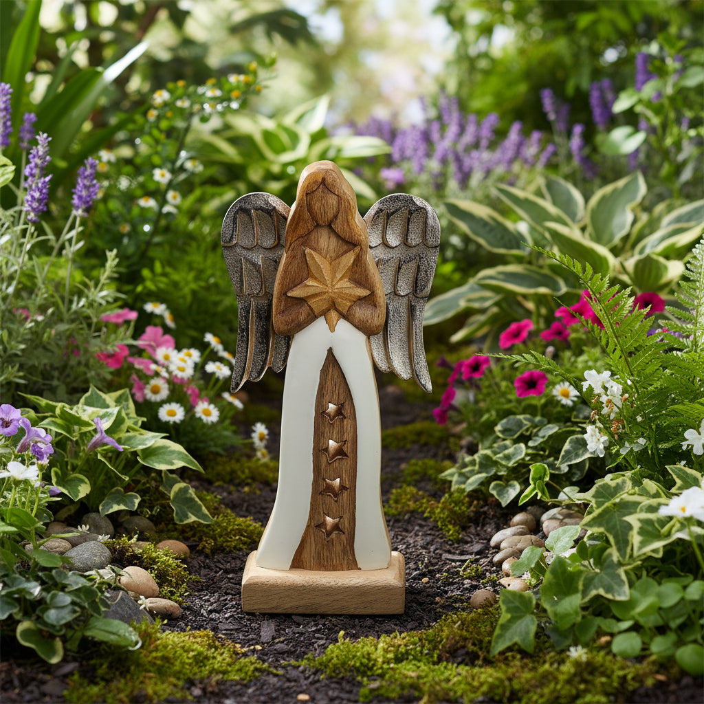 Charming 30cm Mango Wood Angel with Metal Wings & Enamel Detail seen from the back, displaying a golden star held close to her heart in a garden.