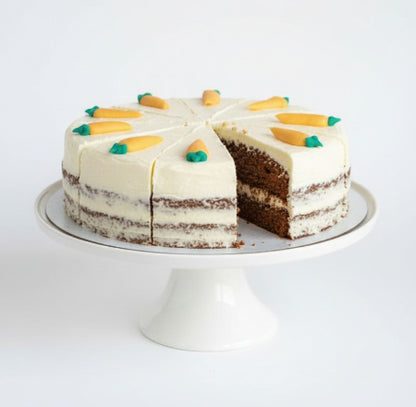 Carrot Layered cake with white frosting and decorative elements on a white stand against a white background